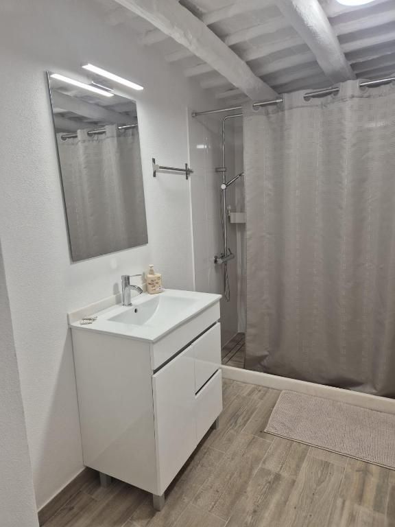 Casa de banho com duche, lavatório e teto de vigas