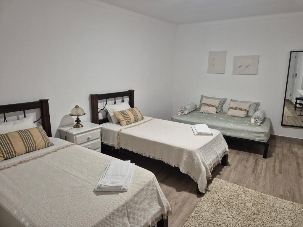 Quarto com duas camas individuais e um sofá-cama